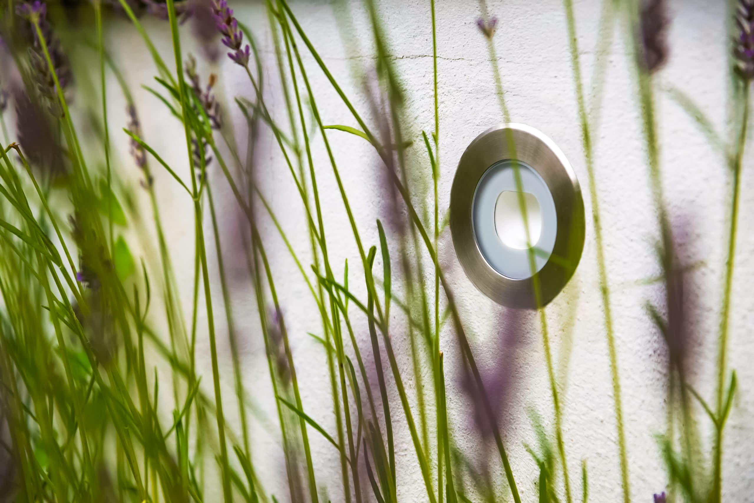exterior stainless steel uplight integrated into garden wall