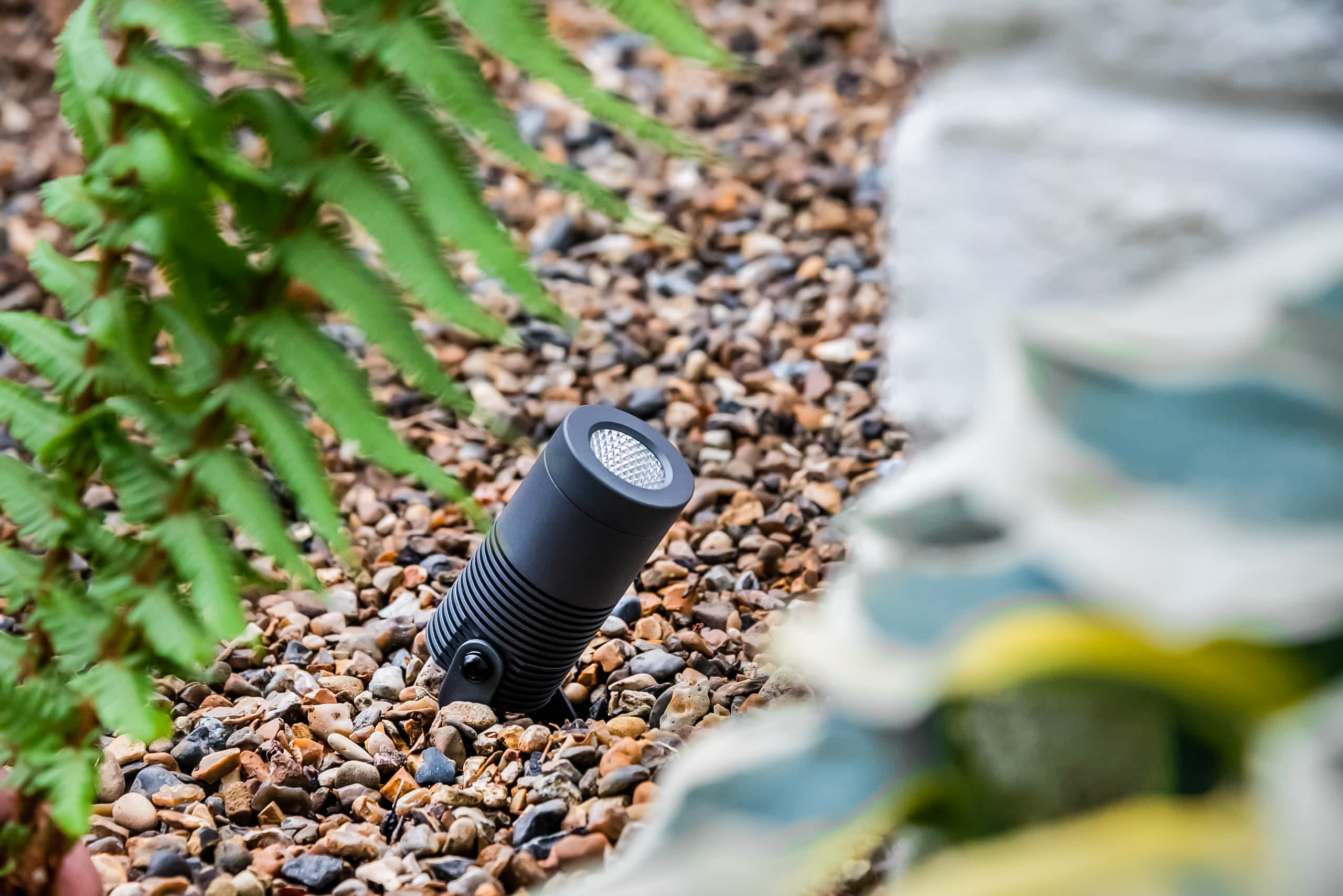medium grey waterproof exterior spotlight in flower bed